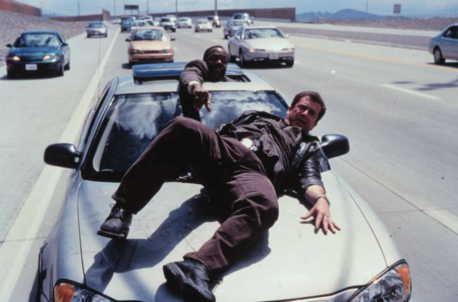 cena de Máquina Mortífera com Mel Gibson e Danny Glover