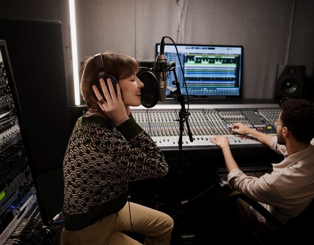 Produtor musical trabalhando em estúdio, mostrando a profissionalização da indústria da música católica com equipamentos de alta qualidade.
